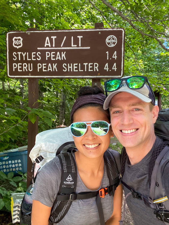 Hikers with trailhead sign